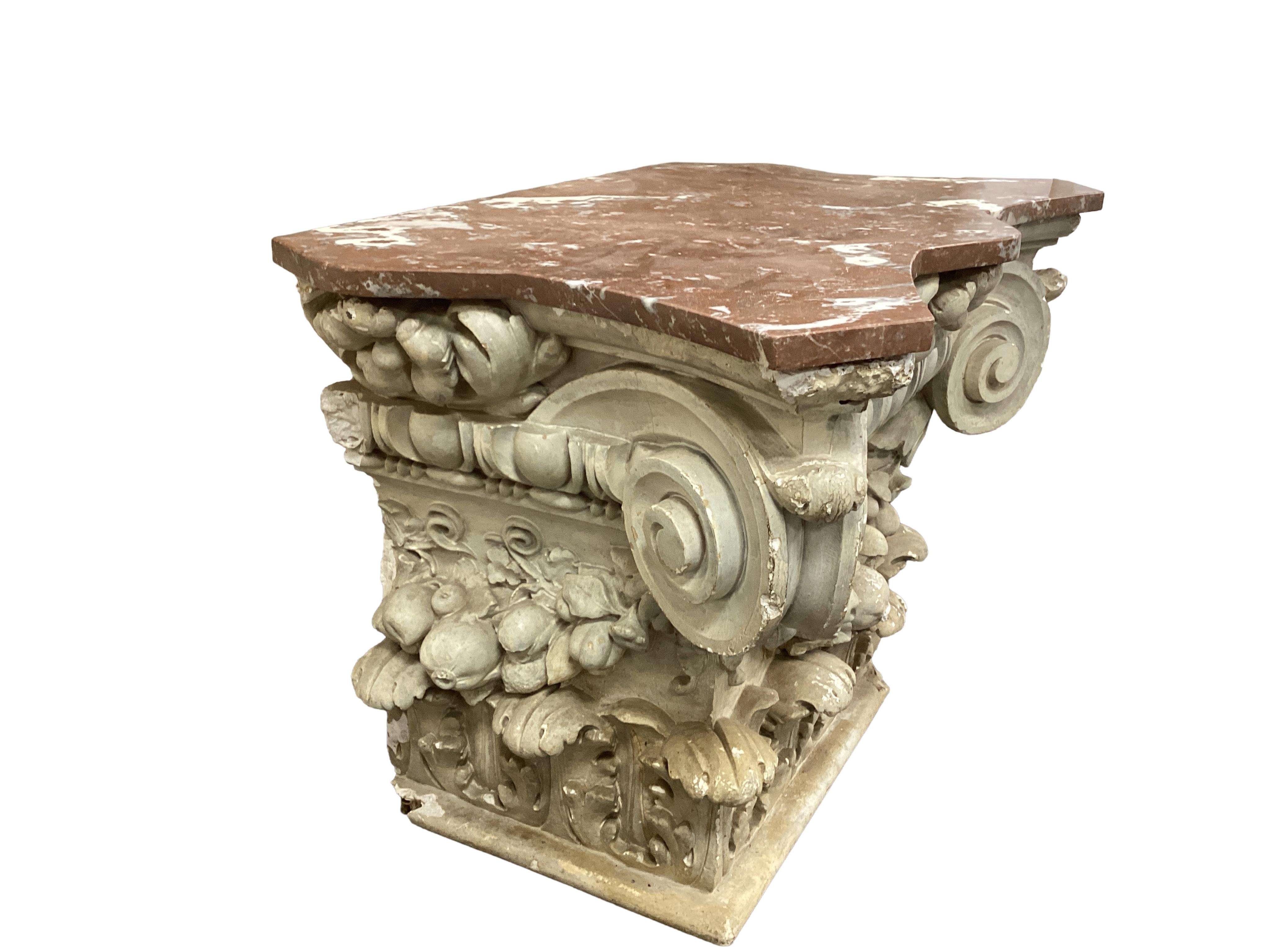 A marble topped white painted composition Ionic capital